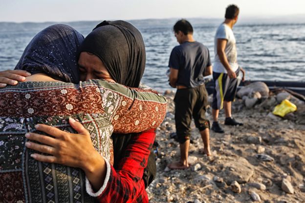 Two women hugging after they reach the coast of Lesbos