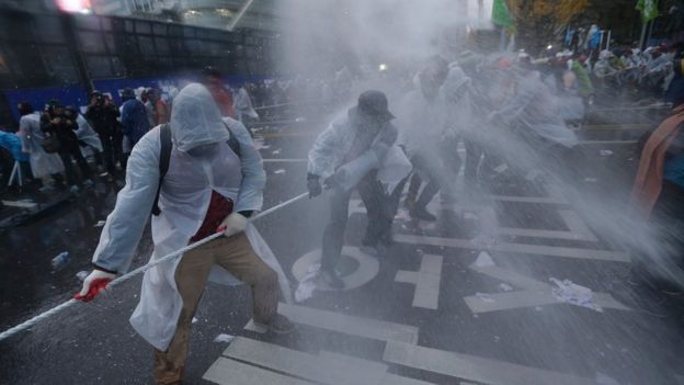 Protesters are sprayed with water cannons during the 14 November rally