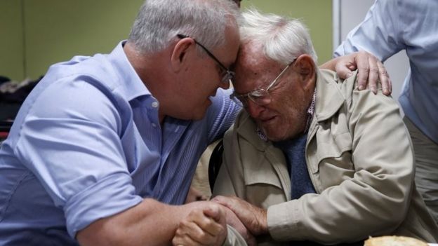 Australian PM Scott Morrison comforts Owen Whalan, a NSW resident who was evacuated