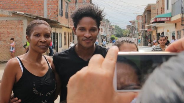 Una admiradora se toma una foto con Fernando Montaño en el barrio de Cali en el que creció el bailarín.