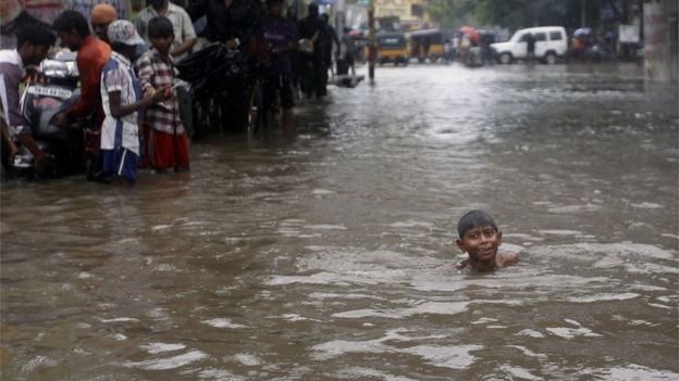 An Indian child swims through a waterlogged subway during heavy rains in Chennai, India, Monday, Nov. 9, 2015.