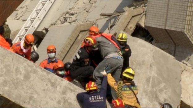 Rescuers carry a male survivor out from a building that collapsed, due to an earthquake, in Tainan, Southern Taiwan, in this February 7, 2016 still image taken from video.