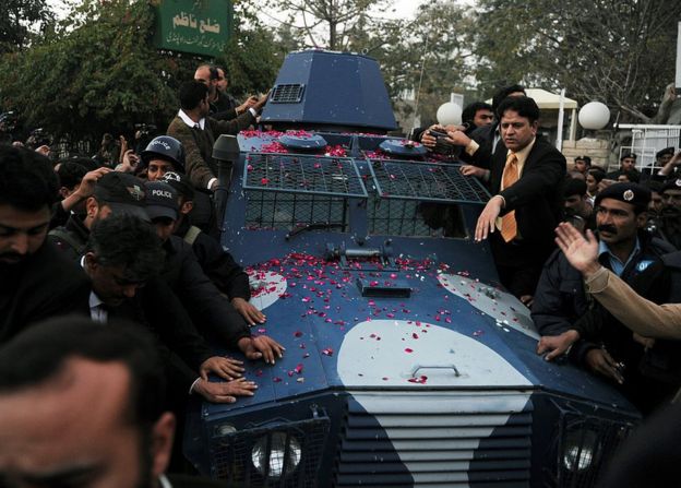 Pakistani police escort an armoured vehicle carrying arrested Pakistani bodyguard Malik Mumtaz Hussain Qadri, the alleged killer of Punjab's governor Salman Taseer, as they leave the anti-terrorist court after a hearing in Rawalpindi on 6 January 2011.