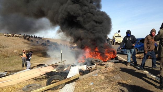 Dakota Access oil pipeline protesters burn debris as officers close in to force them from a camp on private land in the path of pipeline construction, Thursday, Oct. 27, 2016 near Cannon Ball, N.D.