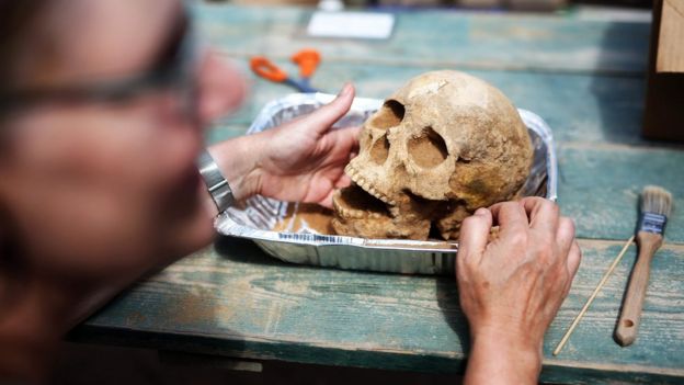 La antropóloga y patóloga Sherry Fox muestra un cráneo descubierto en el sitio de la excavación del primer descubrimiento de un cementerio filisteo, el 28 de junio de 2016.
