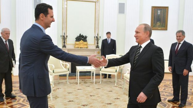 Vladimir Putin shakes hands with Syrian President Bashar Assad in the Kremlin in Moscow