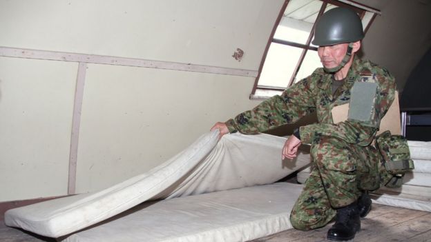 This handout picture provided by Hakodate Shimbun shows a Self-Defense Forces personnel showing inside of a house in a military exercise area in the town of Shikabe