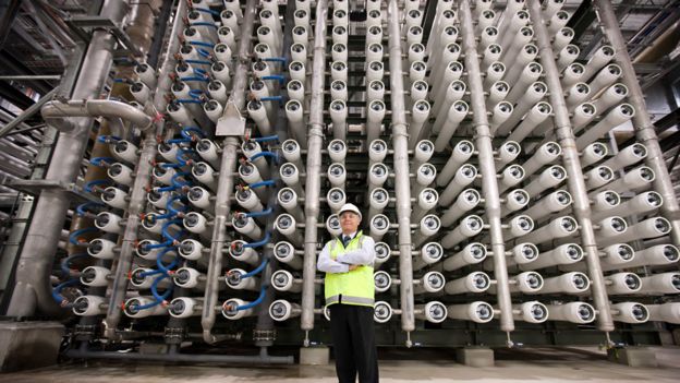 Ingeniero frente a tubos con membranas para filtrar el agua marina en una planta desalinizadora