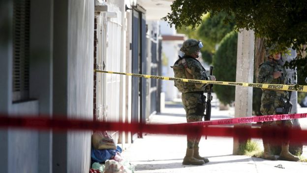 Soldier outside the house where five people were shot dead