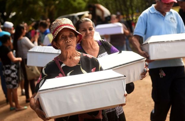 Mujeres cargan ataúdes con las víctimas de la masacre de El Mozote, en El Salvador.