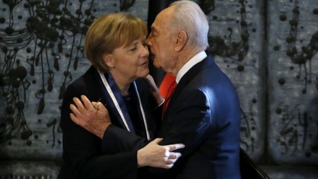 Israeli President Shimon Peres congratulates German Chancellor Angela Merkel as he gives her the Presidential Medal of Distinction in Jerusalem in 2014