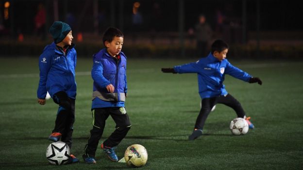 Crianças chinesas jogando futebol