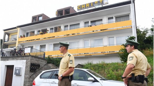 Police officers stand in front of a former hotel where a Syrian man lived before he blew himself up on Sunday at an open-air music festival in Ansbach (25 July 2016)