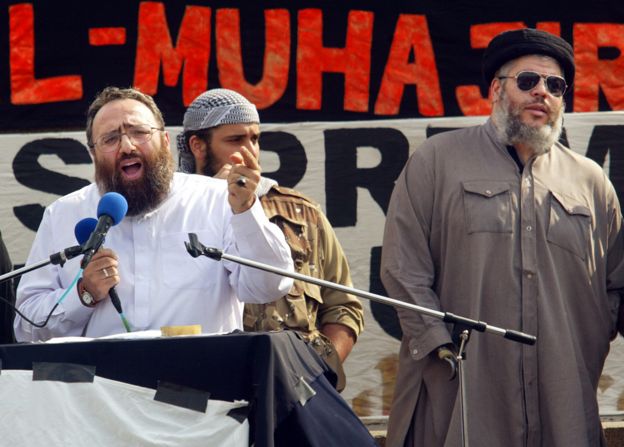 Sheikh Omar Bakri Muhammad (L) gestures while addressing devotees as fellow clergyman Sheikh Abu Hamza (R) waits his turn at the 'Rally for Islam' at Trafalgar Square in central London, 25 August 2002