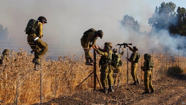 Israeli soldiers inspect a fire near Kfar Sold, north of Israel, caused by four missiles fired from the Syrian side of the Israeli-Syrian border hitting open areas in the Golan Heights and Galilee, causing the fire, on 20 August 2015.