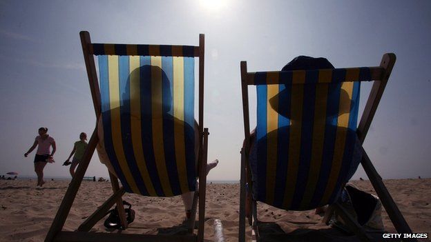 Sunbathers in their deckchairs on a beach
