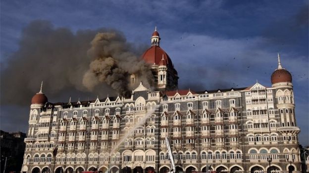Indian firefighters attempt to put out a fire as smoke billows out of the historic Taj Mahal Hotel in Mumbai on November 27, 2008