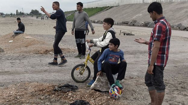 Jóvenes refugiados de Afganistán observan un juego de cricket en Calais, Francia.