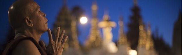 A Buddhist monk prays at the Shwedagon Pagoda at sunrise in Yangon on November 6, 2015