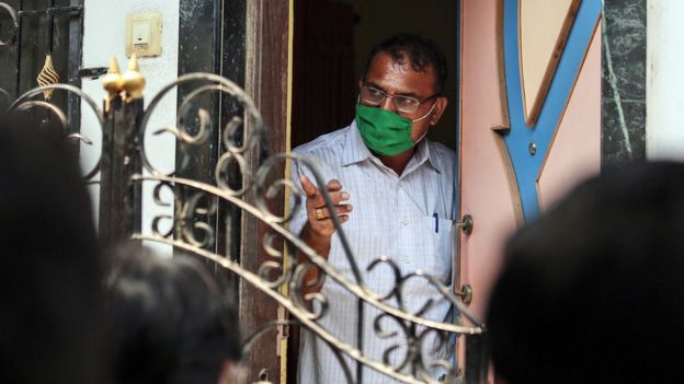 An Indian forensic expert looks from the door of a house in the Kasarvadavali area on the outskirt of Mumbai, India, 28 February 2016, where a 35-year-old man was suspected of murdering 14 family members before hanging himself