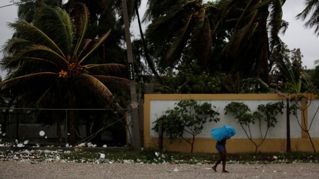 A woman protects herself from rain with an umbrella ahead of Hurricane Matthew in Les Cayes, Haiti