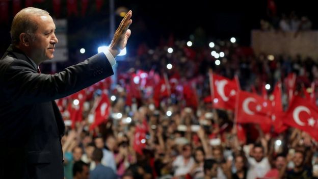 Turkish President Tayyip Erdogan greets his supporters outside of his residence in Istanbul, Turkey, early July 19, 2016, in this handout photo provided by the Presidential Palace
