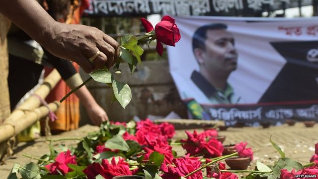 A mourner carries a rose in honour of Avijit Roy