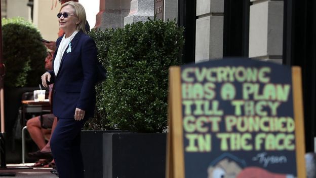 Hillary Clinton walks out of her daughter's apartment after unexpectedly leaving the 9/11 memorial service.