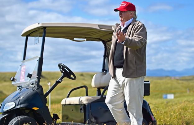 Donald Trump drives a golf buggy during a visits to his Scottish golf course Turnberry in South Ayrshire in 2015