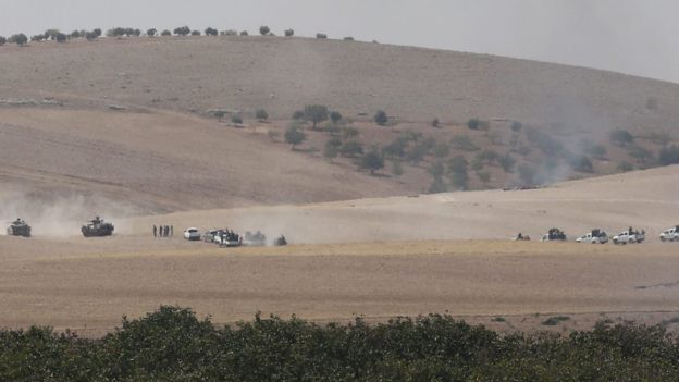 Free Syrian Army fighters in pick-up trucks follow Turkish tanks into Syria, 24 August