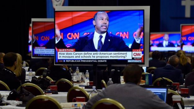 Republican presidential candidate Dr. Ben Carson is seen debating on a video monitor in the press centre during the Republican presidential debate in Las Vegas, Nevada