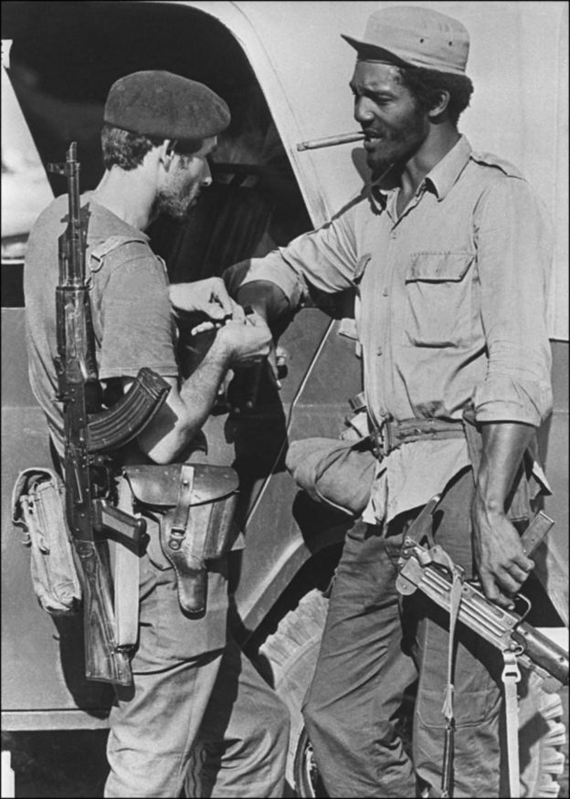 Mwanajeshi wa Cuba na mwenzake wakivuta sigara nchini Angola