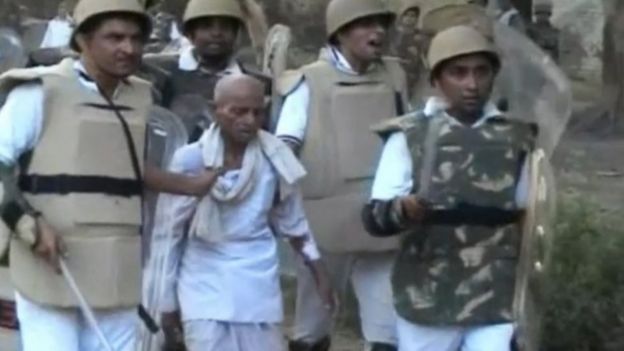 In this Thursday, June 2, 2016 image made from video, paramilitary soldiers detain an unidentified man from the site of violent clashes in Mathura, India