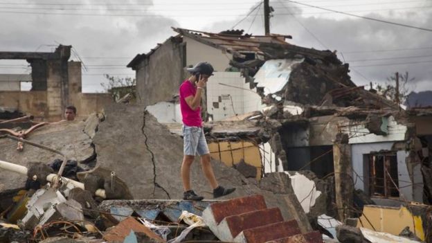 Un joven camina sobre los escombros en Baracoa.