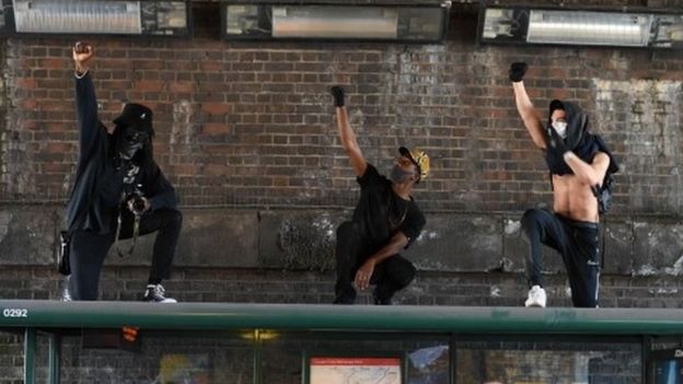 Three men demonstrate on top of a bus stop