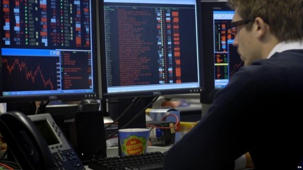 Trader in the City of London watches FTSE 100 index