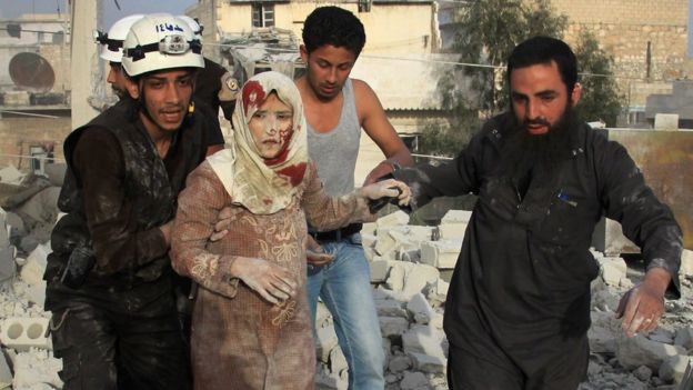 Syrian rescue workers and residents help an injured woman following a reported government air strike on the rebel-held Aleppo district of Haydariya. Photo: April 2016
