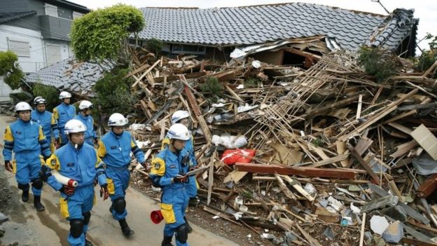 Police officers survey the damages in Mashiki, Kumamoto prefecture (17 April 2016)