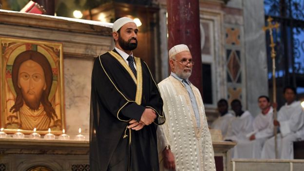 Iman Sami Salem (L) and Imam Mohammed ben Mohammed (R) stand during a mass in the church Santa Maria in trastevere in Rome on July 31, 2016