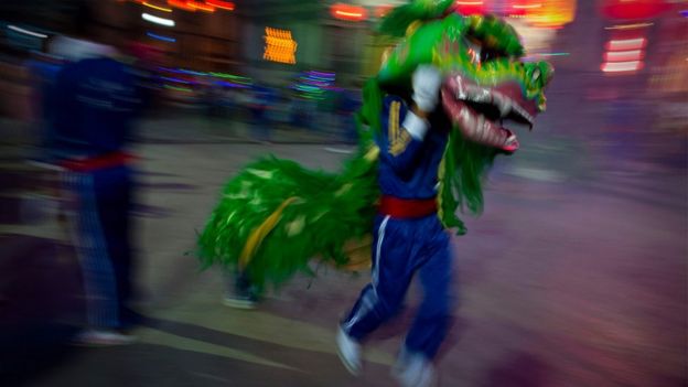 A man performs a dragon dance on the grounds of a Chinese Buddhist temple in Latha township, Yangon