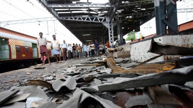 Commuters walk past the blast site at Mahim railway station in Mumbai 12 July 2006.