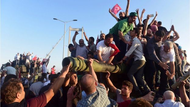 Erdogan supporters on tanks surrendered by coup-plotters on the Bosphorus bridge in Istanbul on 16 July 2016
