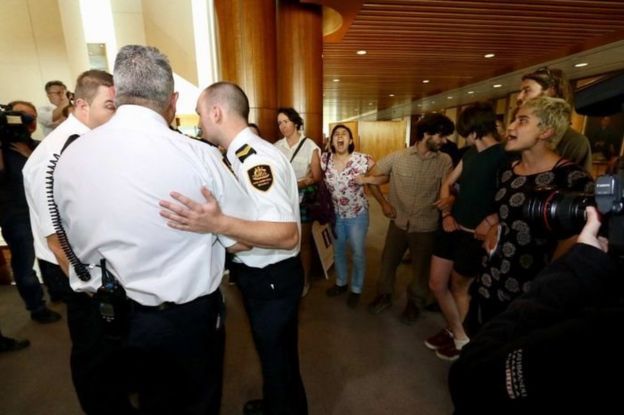 Authorities confer as protesters link arms in the halls of parliament