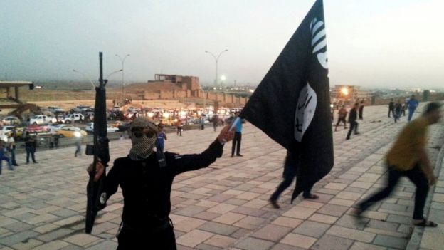 Miembro de EI con bandera posa en Mosul.