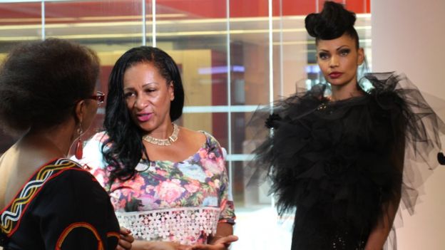 BBC presenter Veronique Edwards talks to designer Mary Martin while a model poses in her design behind her