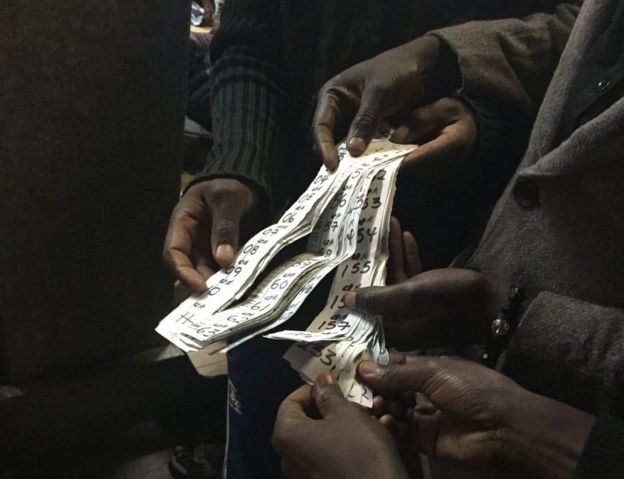 Men distribute numbers to depositors who want to withdraw their money