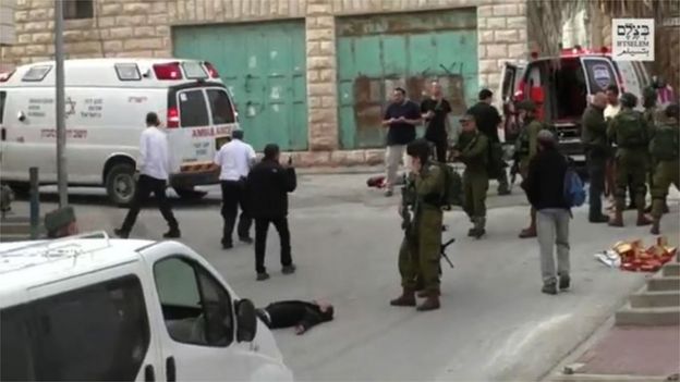 A scene from the video showing Sgt Azaria raising his rifle at the wounded Palestinian