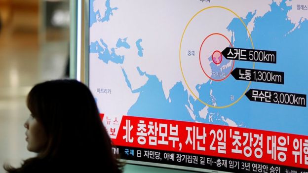 Una mujer pasa por adelante de un televisor donde se ven noticias de Corea del Sur sobre el nuevo lanzamiento de misiles de parte de Corea del Norte.