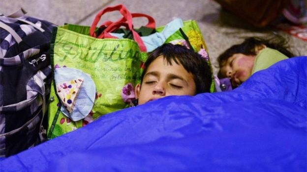 An Afghan migrant child sleeps in the station at Munich, 11 September 2015