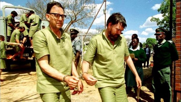 Two white Zimbabwean farmers handcuffed together arrive at a court in Chinhoyi, Zimbabwe, in 2001